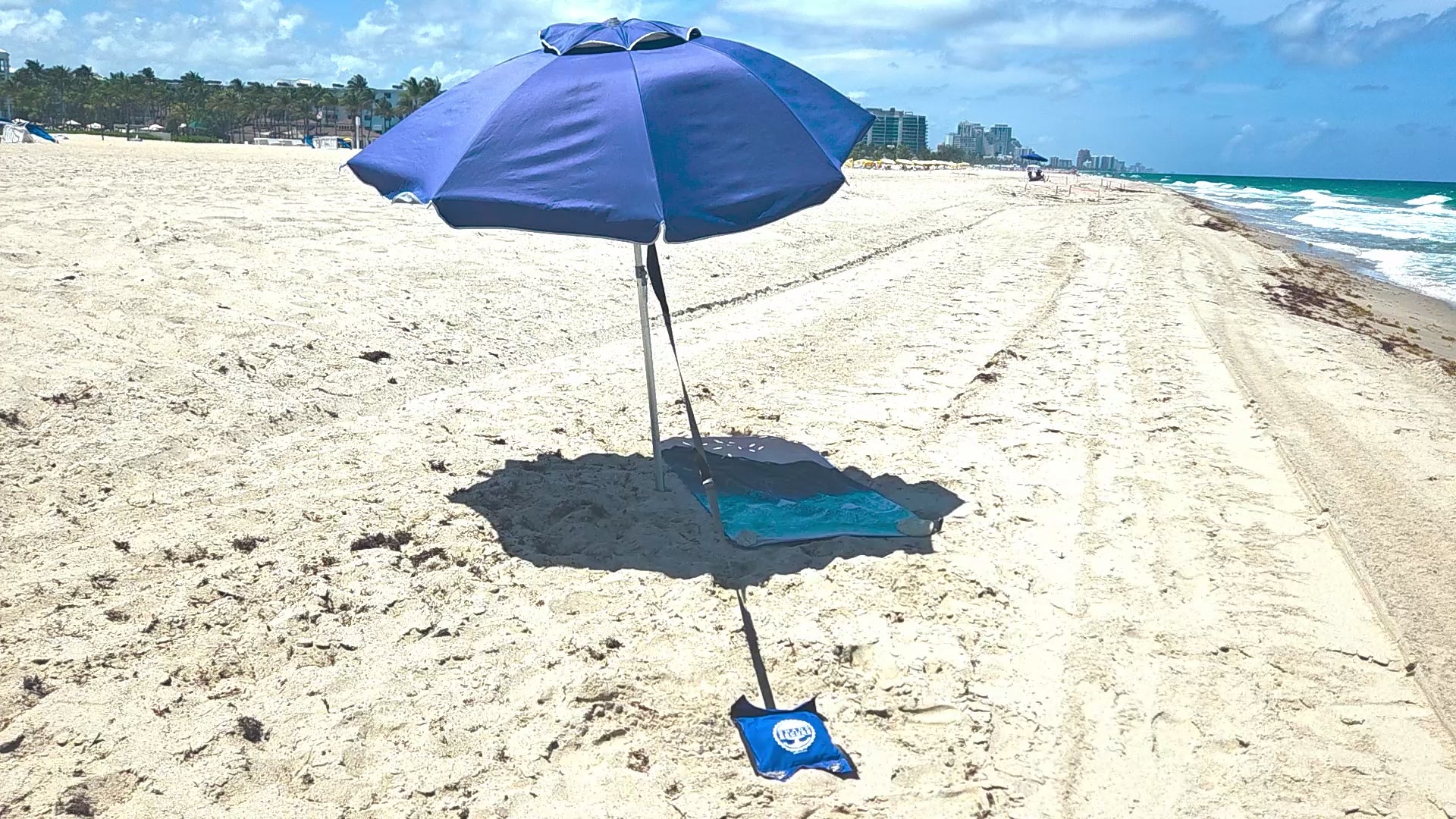 ShadeSecure beach umbrella stabilizer video installed on umbrella in windy beach conditions.